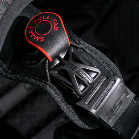 Close-up of a motorcycle helmet chin strap with pull-tab and brand logo.